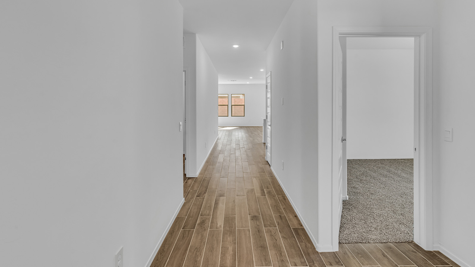 Step into The Cali at Barnett Village, Marana, Arizona – a perfect blend of comfort, modern living, and energy efficiency. This thoughtfully crafted one-story home spans 1,825 square feet and offers ample space featuring 4 bedrooms and 2 bathrooms, ideal for families of all sizes.  As you step through the front porch and into the welcoming entryway, you're immediately led into a thoughtfully designed space that maximizes every square foot. Near the entrance of the home you’ll find 2 bedrooms, ideal for guests or a home office, offering privacy and easy access to the main living areas.  Continuing through the home, you’ll enter the heart of The Cali – an expansive great room that seamlessly connects to the dining area and kitchen. This open-concept space is perfect for entertaining or everyday family living, allowing for a fluid transition from cooking to dining to relaxation. The kitchen is equipped with sleek quartz countertops, modern appliances, a pantry, and an island that doubles as a breakfast bar, providing ample space for meal prep and casual dining.  The primary bedroom, located at the rear of the home, provides a peaceful retreat with a private ensuite bathroom and a generous walk-in closet. The additional four bedrooms are positioned at the front of the house, offering versatility for use as guest rooms, a home office, or children’s bedrooms.  The Cali floor plan offers the option of an extended covered back patio. Whether it’s morning coffee or evening relaxation, this outdoor space extends your living area into the serene landscape of Barnett Village.  Designed with energy efficiency in mind, The Cali at Barnett Village is DOE Zero Energy Ready Home certified, ensuring long-term savings and a comfortable living environment.