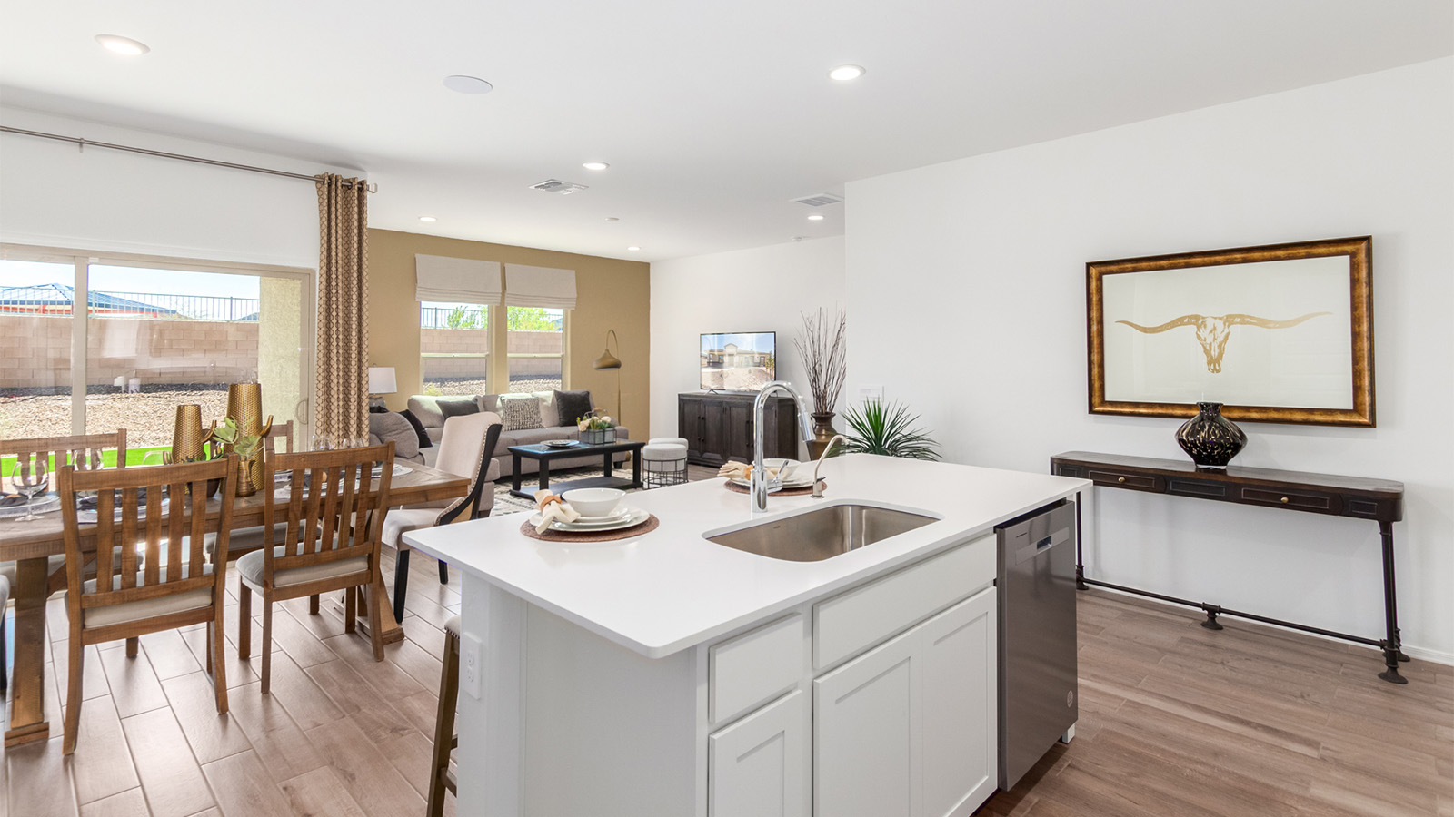 Step into The Cali at Barnett Village, Marana, Arizona – a perfect blend of comfort, modern living, and energy efficiency. This thoughtfully crafted one-story home spans 1,825 square feet and offers ample space featuring 4 bedrooms and 2 bathrooms, ideal for families of all sizes.  As you step through the front porch and into the welcoming entryway, you're immediately led into a thoughtfully designed space that maximizes every square foot. Near the entrance of the home you’ll find 2 bedrooms, ideal for guests or a home office, offering privacy and easy access to the main living areas.  Continuing through the home, you’ll enter the heart of The Cali – an expansive great room that seamlessly connects to the dining area and kitchen. This open-concept space is perfect for entertaining or everyday family living, allowing for a fluid transition from cooking to dining to relaxation. The kitchen is equipped with sleek quartz countertops, modern appliances, a pantry, and an island that doubles as a breakfast bar, providing ample space for meal prep and casual dining.  The primary bedroom, located at the rear of the home, provides a peaceful retreat with a private ensuite bathroom and a generous walk-in closet. The additional four bedrooms are positioned at the front of the house, offering versatility for use as guest rooms, a home office, or children’s bedrooms.  The Cali floor plan offers the option of an extended covered back patio. Whether it’s morning coffee or evening relaxation, this outdoor space extends your living area into the serene landscape of Barnett Village.  Designed with energy efficiency in mind, The Cali at Barnett Village is DOE Zero Energy Ready Home certified, ensuring long-term savings and a comfortable living environment.