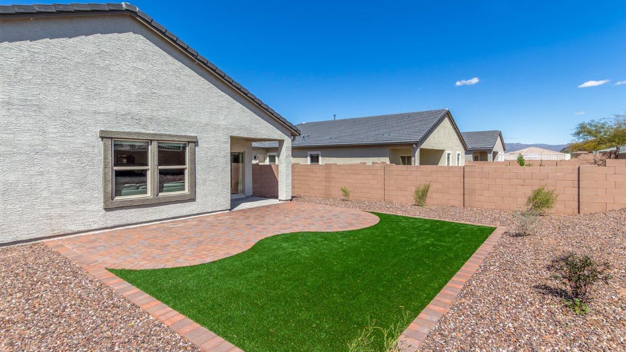 Step into The Cali at Barnett Village, Marana, Arizona – a perfect blend of comfort, modern living, and energy efficiency. This thoughtfully crafted one-story home spans 1,825 square feet and offers ample space featuring 4 bedrooms and 2 bathrooms, ideal for families of all sizes.  As you step through the front porch and into the welcoming entryway, you're immediately led into a thoughtfully designed space that maximizes every square foot. Near the entrance of the home you’ll find 2 bedrooms, ideal for guests or a home office, offering privacy and easy access to the main living areas.  Continuing through the home, you’ll enter the heart of The Cali – an expansive great room that seamlessly connects to the dining area and kitchen. This open-concept space is perfect for entertaining or everyday family living, allowing for a fluid transition from cooking to dining to relaxation. The kitchen is equipped with sleek quartz countertops, modern appliances, a pantry, and an island that doubles as a breakfast bar, providing ample space for meal prep and casual dining.  The primary bedroom, located at the rear of the home, provides a peaceful retreat with a private ensuite bathroom and a generous walk-in closet. The additional four bedrooms are positioned at the front of the house, offering versatility for use as guest rooms, a home office, or children’s bedrooms.  The Cali floor plan offers the option of an extended covered back patio. Whether it’s morning coffee or evening relaxation, this outdoor space extends your living area into the serene landscape of Barnett Village.  Designed with energy efficiency in mind, The Cali at Barnett Village is DOE Zero Energy Ready Home certified, ensuring long-term savings and a comfortable living environment.