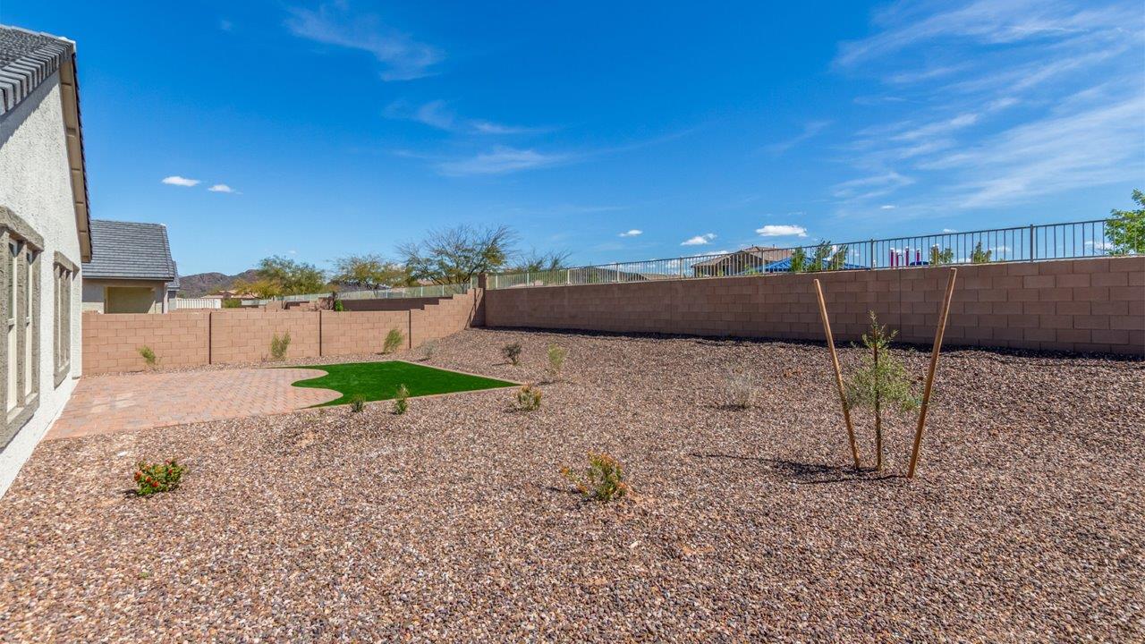 Step into The Cali at Barnett Village, Marana, Arizona – a perfect blend of comfort, modern living, and energy efficiency. This thoughtfully crafted one-story home spans 1,825 square feet and offers ample space featuring 4 bedrooms and 2 bathrooms, ideal for families of all sizes.  As you step through the front porch and into the welcoming entryway, you're immediately led into a thoughtfully designed space that maximizes every square foot. Near the entrance of the home you’ll find 2 bedrooms, ideal for guests or a home office, offering privacy and easy access to the main living areas.  Continuing through the home, you’ll enter the heart of The Cali – an expansive great room that seamlessly connects to the dining area and kitchen. This open-concept space is perfect for entertaining or everyday family living, allowing for a fluid transition from cooking to dining to relaxation. The kitchen is equipped with sleek quartz countertops, modern appliances, a pantry, and an island that doubles as a breakfast bar, providing ample space for meal prep and casual dining.  The primary bedroom, located at the rear of the home, provides a peaceful retreat with a private ensuite bathroom and a generous walk-in closet. The additional four bedrooms are positioned at the front of the house, offering versatility for use as guest rooms, a home office, or children’s bedrooms.  The Cali floor plan offers the option of an extended covered back patio. Whether it’s morning coffee or evening relaxation, this outdoor space extends your living area into the serene landscape of Barnett Village.  Designed with energy efficiency in mind, The Cali at Barnett Village is DOE Zero Energy Ready Home certified, ensuring long-term savings and a comfortable living environment.