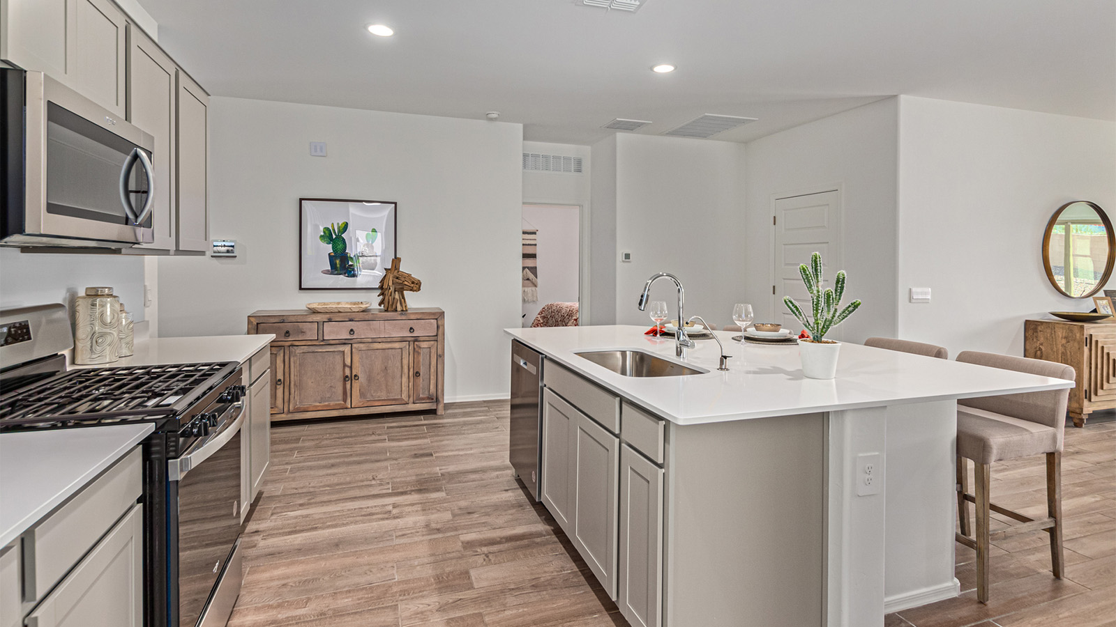 Step into The Kingston at Barnett Village, Marana, Arizona – a perfect blend of comfort, modern living, and energy efficiency. This thoughtfully crafted one-story home spans 2,068 square feet and offers four bedrooms and two bathrooms, ideal for families of all sizes.  The open-concept design features a spacious great room that effortlessly connects with the kitchen and dining area, creating an inviting central hub for everyday living and entertaining. The kitchen is equipped with contemporary appliances and a pantry, offering ample storage and convenience for meal preparation.  The primary bedroom, located at the rear of the home, provides a peaceful retreat with a private ensuite bathroom and a generous walk-in closet. The additional three bedrooms are positioned at the front of the house, offering versatility for use as guest rooms, a home office, or children’s bedrooms. Step outside to the covered patio, a perfect spot to enjoy the beautiful Arizona weather, whether for morning coffee or evening relaxation.  The Kingston also boasts a covered patio, perfect for enjoying Arizona’s beautiful desert evenings. Whether it’s morning coffee or evening relaxation, this outdoor space extends your living area into the serene landscape of Barnett Village.  Built with energy efficiency as a priority, the Kingston includes smart home technology, which not only simplifies daily living but also helps reduce utility costs. A two-car garage provides ample parking and additional storage space, enhancing the home’s functionality.  *Images shown are for reference only. They depict The Kingston sales model home and may not represent the actual home.