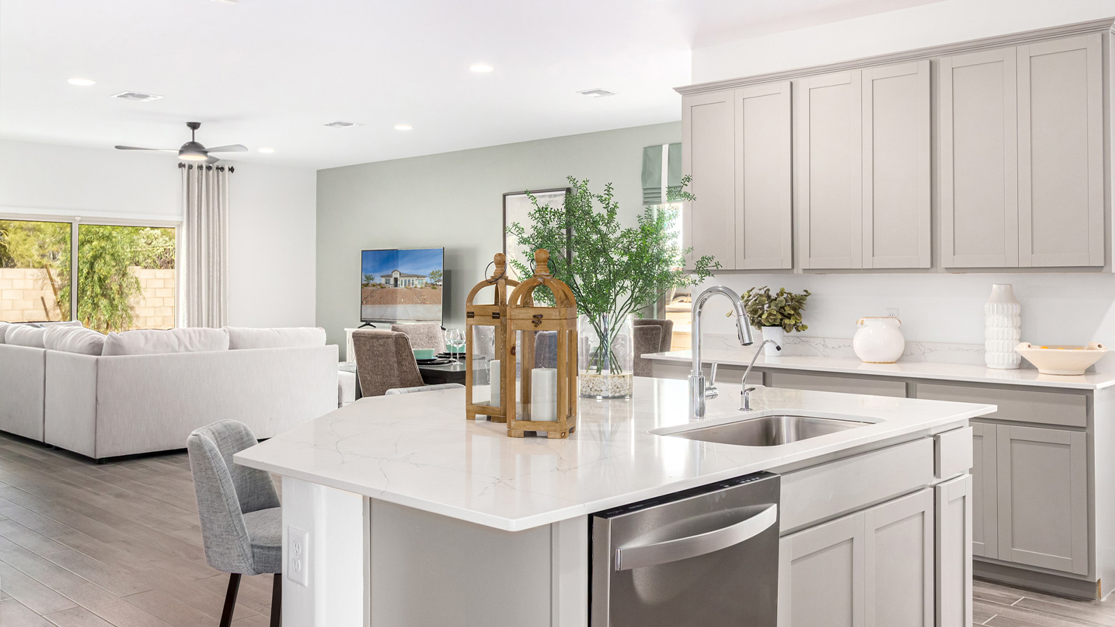 Step into The Kingston at Barnett Village, Marana, Arizona – a perfect blend of comfort, modern living, and energy efficiency. This thoughtfully crafted one-story home spans 2,068 square feet and offers four bedrooms and two bathrooms, ideal for families of all sizes.  The open-concept design features a spacious great room that effortlessly connects with the kitchen and dining area, creating an inviting central hub for everyday living and entertaining. The kitchen is equipped with contemporary appliances and a pantry, offering ample storage and convenience for meal preparation.  The primary bedroom, located at the rear of the home, provides a peaceful retreat with a private ensuite bathroom and a generous walk-in closet. The additional three bedrooms are positioned at the front of the house, offering versatility for use as guest rooms, a home office, or children’s bedrooms. Step outside to the covered patio, a perfect spot to enjoy the beautiful Arizona weather, whether for morning coffee or evening relaxation.  The Kingston also boasts a covered patio, perfect for enjoying Arizona’s beautiful desert evenings. Whether it’s morning coffee or evening relaxation, this outdoor space extends your living area into the serene landscape of Barnett Village.  Built with energy efficiency as a priority, the Kingston includes smart home technology, which not only simplifies daily living but also helps reduce utility costs. A two-car garage provides ample parking and additional storage space, enhancing the home’s functionality.