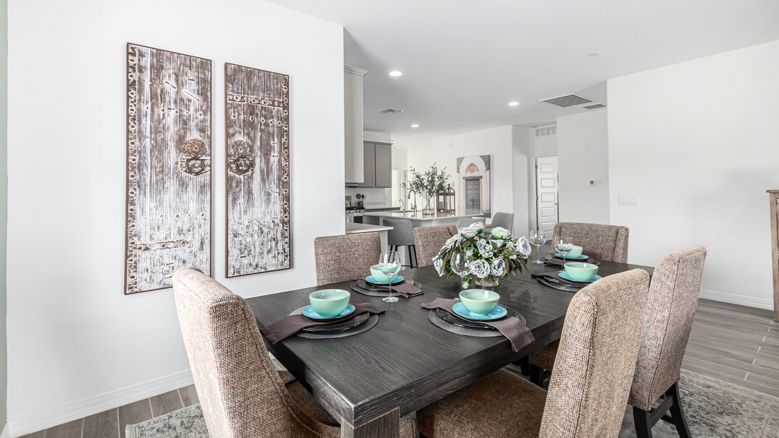 Step into The Kingston at Barnett Village, Marana, Arizona – a perfect blend of comfort, modern living, and energy efficiency. This thoughtfully crafted one-story home spans 2,068 square feet and offers four bedrooms and two bathrooms, ideal for families of all sizes.  The open-concept design features a spacious great room that effortlessly connects with the kitchen and dining area, creating an inviting central hub for everyday living and entertaining. The kitchen is equipped with contemporary appliances and a pantry, offering ample storage and convenience for meal preparation.  The primary bedroom, located at the rear of the home, provides a peaceful retreat with a private ensuite bathroom and a generous walk-in closet. The additional three bedrooms are positioned at the front of the house, offering versatility for use as guest rooms, a home office, or children’s bedrooms. Step outside to the covered patio, a perfect spot to enjoy the beautiful Arizona weather, whether for morning coffee or evening relaxation.  The Kingston also boasts a covered patio, perfect for enjoying Arizona’s beautiful desert evenings. Whether it’s morning coffee or evening relaxation, this outdoor space extends your living area into the serene landscape of Barnett Village.  Built with energy efficiency as a priority, the Kingston includes smart home technology, which not only simplifies daily living but also helps reduce utility costs. A two-car garage provides ample parking and additional storage space, enhancing the home’s functionality.