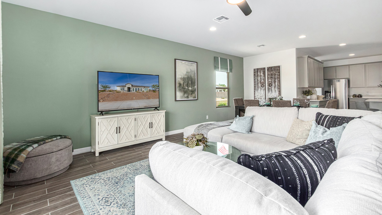 Step into The Kingston at Barnett Village, Marana, Arizona – a perfect blend of comfort, modern living, and energy efficiency. This thoughtfully crafted one-story home spans 2,068 square feet and offers four bedrooms and two bathrooms, ideal for families of all sizes.  The open-concept design features a spacious great room that effortlessly connects with the kitchen and dining area, creating an inviting central hub for everyday living and entertaining. The kitchen is equipped with contemporary appliances and a pantry, offering ample storage and convenience for meal preparation.  The primary bedroom, located at the rear of the home, provides a peaceful retreat with a private ensuite bathroom and a generous walk-in closet. The additional three bedrooms are positioned at the front of the house, offering versatility for use as guest rooms, a home office, or children’s bedrooms. Step outside to the covered patio, a perfect spot to enjoy the beautiful Arizona weather, whether for morning coffee or evening relaxation.  The Kingston also boasts a covered patio, perfect for enjoying Arizona’s beautiful desert evenings. Whether it’s morning coffee or evening relaxation, this outdoor space extends your living area into the serene landscape of Barnett Village.  Built with energy efficiency as a priority, the Kingston includes smart home technology, which not only simplifies daily living but also helps reduce utility costs. A two-car garage provides ample parking and additional storage space, enhancing the home’s functionality.