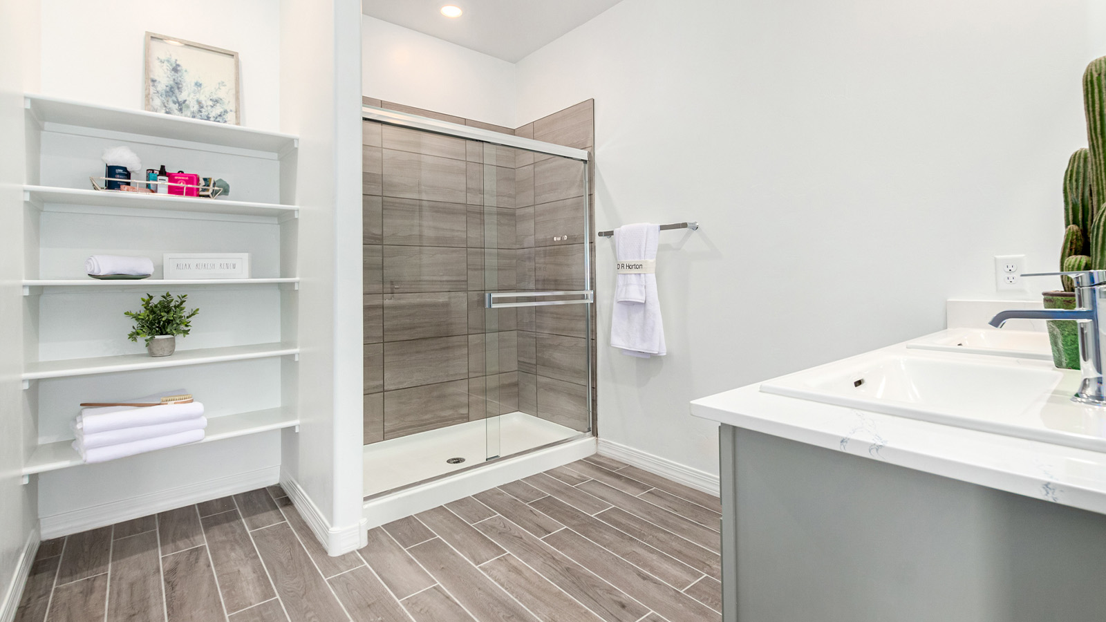 Step into The Kingston at Barnett Village, Marana, Arizona – a perfect blend of comfort, modern living, and energy efficiency. This thoughtfully crafted one-story home spans 2,068 square feet and offers four bedrooms and two bathrooms, ideal for families of all sizes.  The open-concept design features a spacious great room that effortlessly connects with the kitchen and dining area, creating an inviting central hub for everyday living and entertaining. The kitchen is equipped with contemporary appliances and a pantry, offering ample storage and convenience for meal preparation.  The primary bedroom, located at the rear of the home, provides a peaceful retreat with a private ensuite bathroom and a generous walk-in closet. The additional three bedrooms are positioned at the front of the house, offering versatility for use as guest rooms, a home office, or children’s bedrooms. Step outside to the covered patio, a perfect spot to enjoy the beautiful Arizona weather, whether for morning coffee or evening relaxation.  The Kingston also boasts a covered patio, perfect for enjoying Arizona’s beautiful desert evenings. Whether it’s morning coffee or evening relaxation, this outdoor space extends your living area into the serene landscape of Barnett Village.  Built with energy efficiency as a priority, the Kingston includes smart home technology, which not only simplifies daily living but also helps reduce utility costs. A two-car garage provides ample parking and additional storage space, enhancing the home’s functionality.