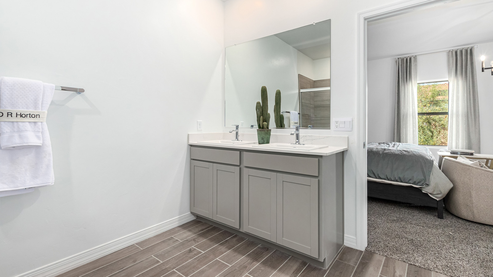 Step into The Kingston at Barnett Village, Marana, Arizona – a perfect blend of comfort, modern living, and energy efficiency. This thoughtfully crafted one-story home spans 2,068 square feet and offers four bedrooms and two bathrooms, ideal for families of all sizes.  The open-concept design features a spacious great room that effortlessly connects with the kitchen and dining area, creating an inviting central hub for everyday living and entertaining. The kitchen is equipped with contemporary appliances and a pantry, offering ample storage and convenience for meal preparation.  The primary bedroom, located at the rear of the home, provides a peaceful retreat with a private ensuite bathroom and a generous walk-in closet. The additional three bedrooms are positioned at the front of the house, offering versatility for use as guest rooms, a home office, or children’s bedrooms. Step outside to the covered patio, a perfect spot to enjoy the beautiful Arizona weather, whether for morning coffee or evening relaxation.  The Kingston also boasts a covered patio, perfect for enjoying Arizona’s beautiful desert evenings. Whether it’s morning coffee or evening relaxation, this outdoor space extends your living area into the serene landscape of Barnett Village.  Built with energy efficiency as a priority, the Kingston includes smart home technology, which not only simplifies daily living but also helps reduce utility costs. A two-car garage provides ample parking and additional storage space, enhancing the home’s functionality.