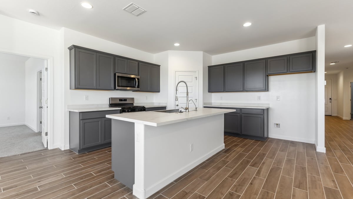 Introducing The Garland, a thoughtfully crafted single-story home at Entrada Del Toro, nestled within the highly sought-after community of Rancho Sahuarita. Offering 2,273 square feet of generous living space, The Garland is designed for households seeking room to grow, flexible living options, and refined modern comfort. This expansive floor plan features four bedrooms, three full bathrooms, a spacious kitchen, a covered back patio, and a three-car garage—perfectly balancing style and functionality.  A welcoming entryway opens into a bright, open-concept design where the great room, dining area, and kitchen flow seamlessly together, creating an ideal setting for both everyday living and entertaining. The kitchen truly anchors the home, showcasing quartz countertops, Shaker-style cabinetry, a large center island ideal for casual dining or meal prep, a pantry, and abundant storage throughout.  Thoughtfully designed with privacy in mind, The Garland offers a desirable split-bedroom layout. Three secondary bedrooms are positioned near the front of the home, including one with its own private en-suite bathroom—perfect for guests, extended family, or multigenerational living. Tucked away at the rear of the home, the expansive primary suite serves as a tranquil retreat, featuring two generous walk-in closets and a well-appointed en-suite bathroom.  Step outside to the covered back patio, an inviting extension of the living space that’s ideal for outdoor dining, relaxing evenings, or entertaining year-round. Homes at Entrada Del Toro are designed for both style and future-forward living, with exterior features including a light lace stucco finish, professionally landscaped front yards with automatic drip irrigation, and large, fully fenced backyards ready for your personal touch.  Inside, the Home Is Connected® Smart Home package enhances everyday convenience with a smart thermostat, video doorbell, keyless entry, and a Wi-Fi® enabled garage door opener.  With its spacious footprint, thoughtful layout, and modern design elements, The Garland delivers the perfect blend of comfort, functionality, and flexibility for today’s lifestyle.  Residents of Entrada Del Toro enjoy access to Rancho Sahuarita’s exceptional resort-style amenities, including a full-service fitness center, multiple swimming pools, pickleball courts, splash pads, playgrounds, and expansive parks for all ages. Homeowners will also enjoy exclusive access to the brand-new Entrada Del Toro Community Center, scheduled to open in Spring 2026, offering modern gathering spaces and recreational amenities just moments from home.