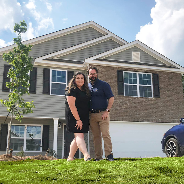 Happy family in front of new house